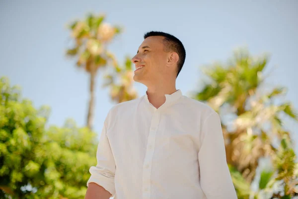 Joven Guapo Con Una Camisa Blanca Levanta Sobre Fondo Palmeras — Foto de Stock