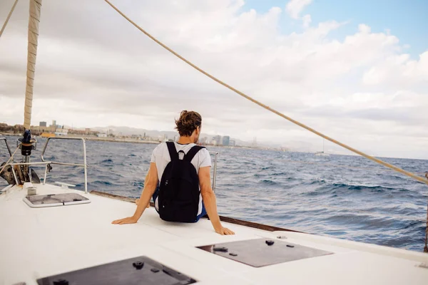 Guy Traveler Backpack Sits Sailing Yacht Enjoys Views Man Yacht — Stock Photo, Image