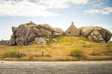 17. yüzyılın ünlü muhafız kulübesi, Fransa 'nın Brittany, Meneham kentindeki eski balıkçı köyünde bulunan iki granit kayanın arasına sıkışmış. Aydınlık ve güneşli bir günde yol manzarası.