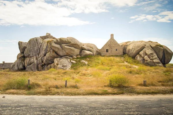 17. yüzyılın ünlü muhafız kulübesi, Fransa 'nın Brittany, Meneham kentindeki eski balıkçı köyünde bulunan iki granit kayanın arasına sıkışmış. Aydınlık ve güneşli bir günde yol manzarası.