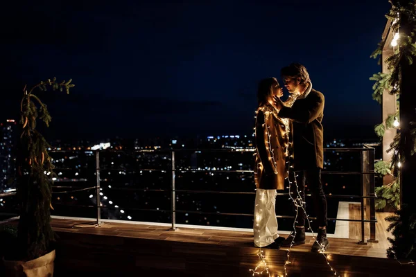 young couple in love  with garlands at night