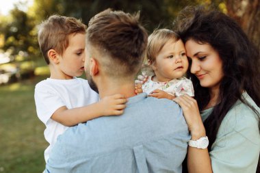 Parkta dinlenen çocuklu mutlu bir aile.