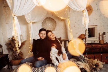 Mutlu çift Noel dekoru ile odada dinleniyor.