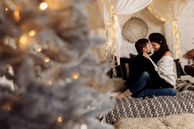 Mutlu çift Noel dekoru ile odada dinleniyor.