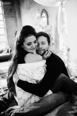 Mutlu çift Noel dekoru ile odada dinleniyor.