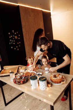 Genç ve mutlu bir aile mutfakta yemek yiyor.