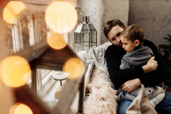 Baba oğul evdeki kanepede oturuyorlar. 