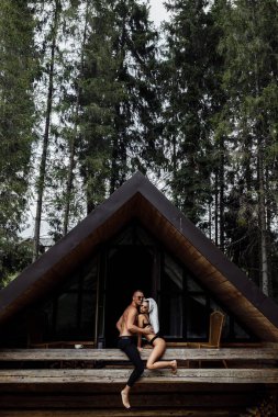 Genç bayan ormanın arka tarafındaki evin yanında.