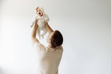 Genç, mutlu bir baba ve beyaz arka planda küçük bir kız.