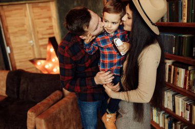 Mutlu genç aile evde poz veriyor.