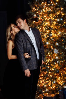 Harika evli çift Noel ağacının yanında poz veriyor.