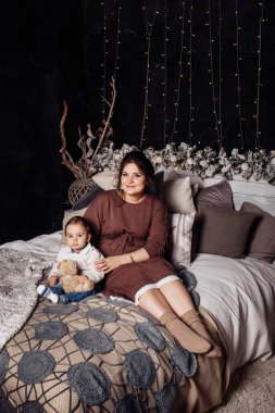 Mutlu anne ve oğul yatakta poz veriyor. 