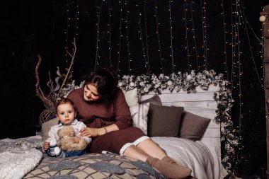 Mutlu anne ve oğul yatakta poz veriyor. 