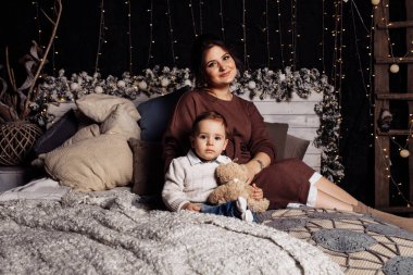 Mutlu anne ve oğul yatakta poz veriyor. 