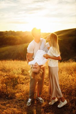 Mutlu genç aile gün batımında tarlada 