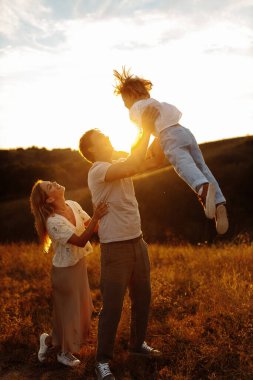 Mutlu genç aile gün batımında tarlada 