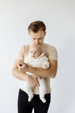 Genç, mutlu bir baba ve beyaz arka planda küçük bir kız.