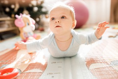 Tatlı kız yerde oynuyor.