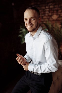 Genç yakışıklı damat içeride poz veriyor.
