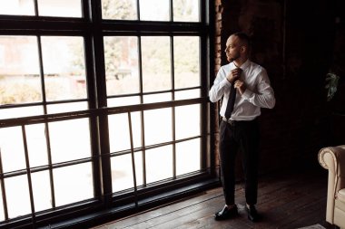 Genç yakışıklı damat içeride poz veriyor.