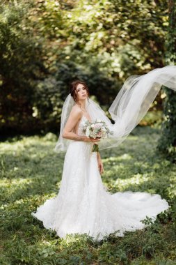 Çiçeklerle poz veren güzel genç gelin 