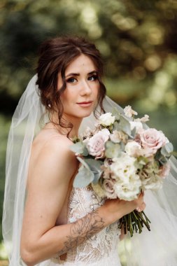 Çiçeklerle poz veren güzel genç gelin 