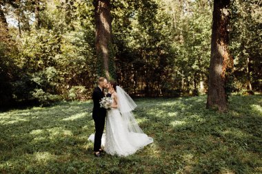 Yeni evli çiftimiz dışarıda öpüşüyor.