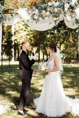 Açık havada seremoni yapan mutlu genç bir çift.