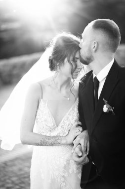 Yeni evli çiftimiz dışarıda öpüşüyor.