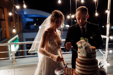 Düğün pastası olan mutlu, genç bir çift. 