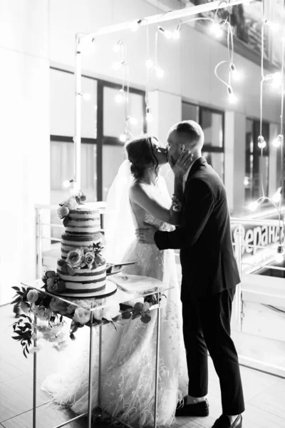 ケーキのキスで新婚カップルの美しい若い — ストック写真