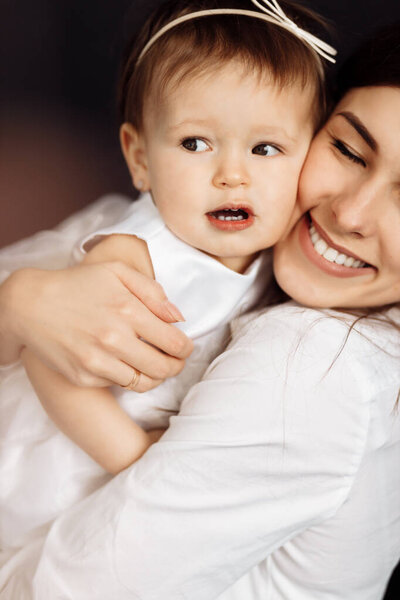 happy mother and daughter posing in studio