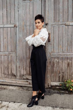 Beyaz bluzlu güzel bir kadın poz veriyor. 