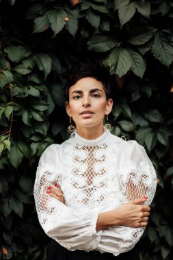 Beyaz bluzlu güzel bir kadın poz veriyor. 