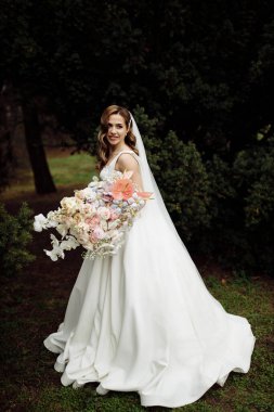 Çiçekleri olan zarif, genç bir gelin.