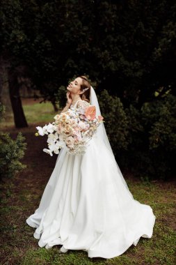 Çiçekleri olan zarif, genç bir gelin.