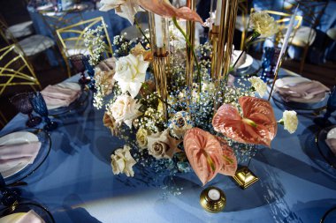 Arka planda çiçekler olan düğün masası ayarları