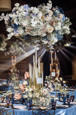 Arka planda çiçekler olan düğün masası ayarları