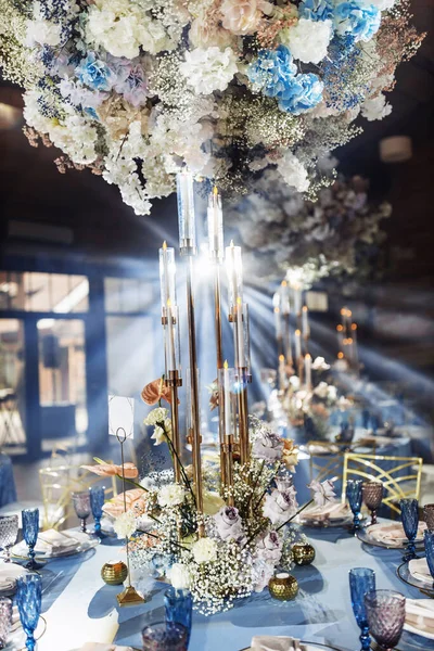 Arka planda çiçekler olan düğün masası ayarları