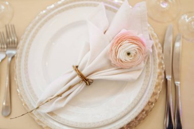 Beyaz çiçek ve gümüş çatal bıçaklı düğün masası.