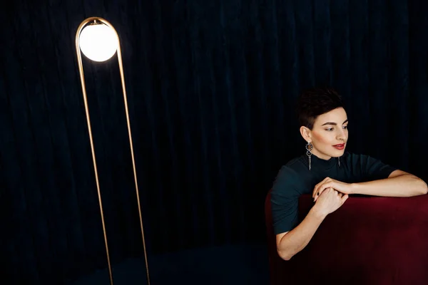 portrait of  beautiful young woman   on chair  in studio