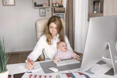 Genç anne ve kızı bilgisayar başında oturuyorlar.