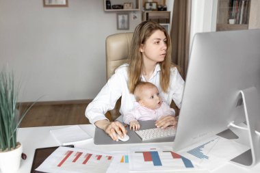 Genç anne ve kızı bilgisayar başında oturuyorlar.