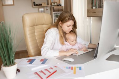 Genç anne ve kızı bilgisayar başında oturuyorlar.