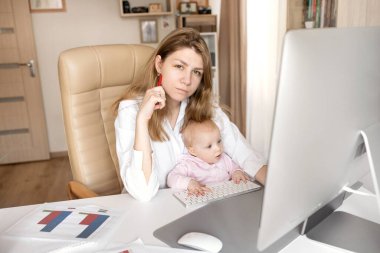 Genç anne ve kızı bilgisayar başında oturuyorlar.