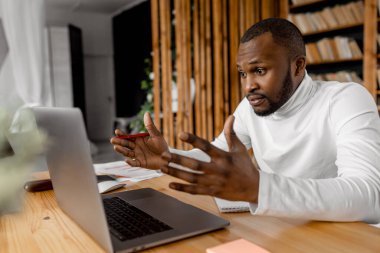 Ofisinde dizüstü bilgisayarı olan Afrikalı Amerikalı serbest yazar.