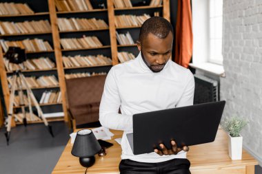Ofisinde dizüstü bilgisayarı olan Afrikalı Amerikalı serbest yazar.