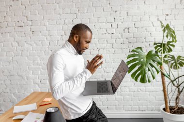 Ofisinde dizüstü bilgisayarı olan Afrikalı Amerikalı serbest yazar.