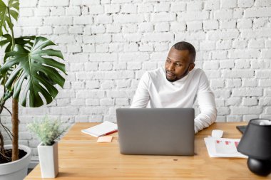 Ofisinde dizüstü bilgisayarı olan Afrikalı Amerikalı serbest yazar.