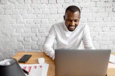 Ofisinde dizüstü bilgisayarı olan Afrikalı Amerikalı serbest yazar.